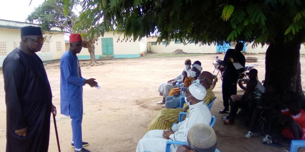 Diomandé Gouamou en chapeau rouge sensilibilant les leaders communautaires de Touba